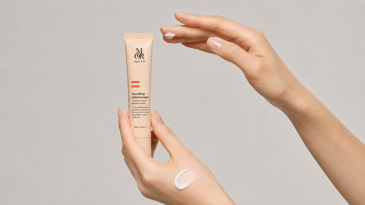 Hands presenting Glow Lifting Radiance Cream with a cream swatch on the back of the hand