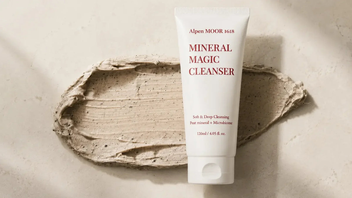 Alpen MOOR 1618 Mineral Magic Cleanser tube resting on a swipe of its grey mineral cream texture